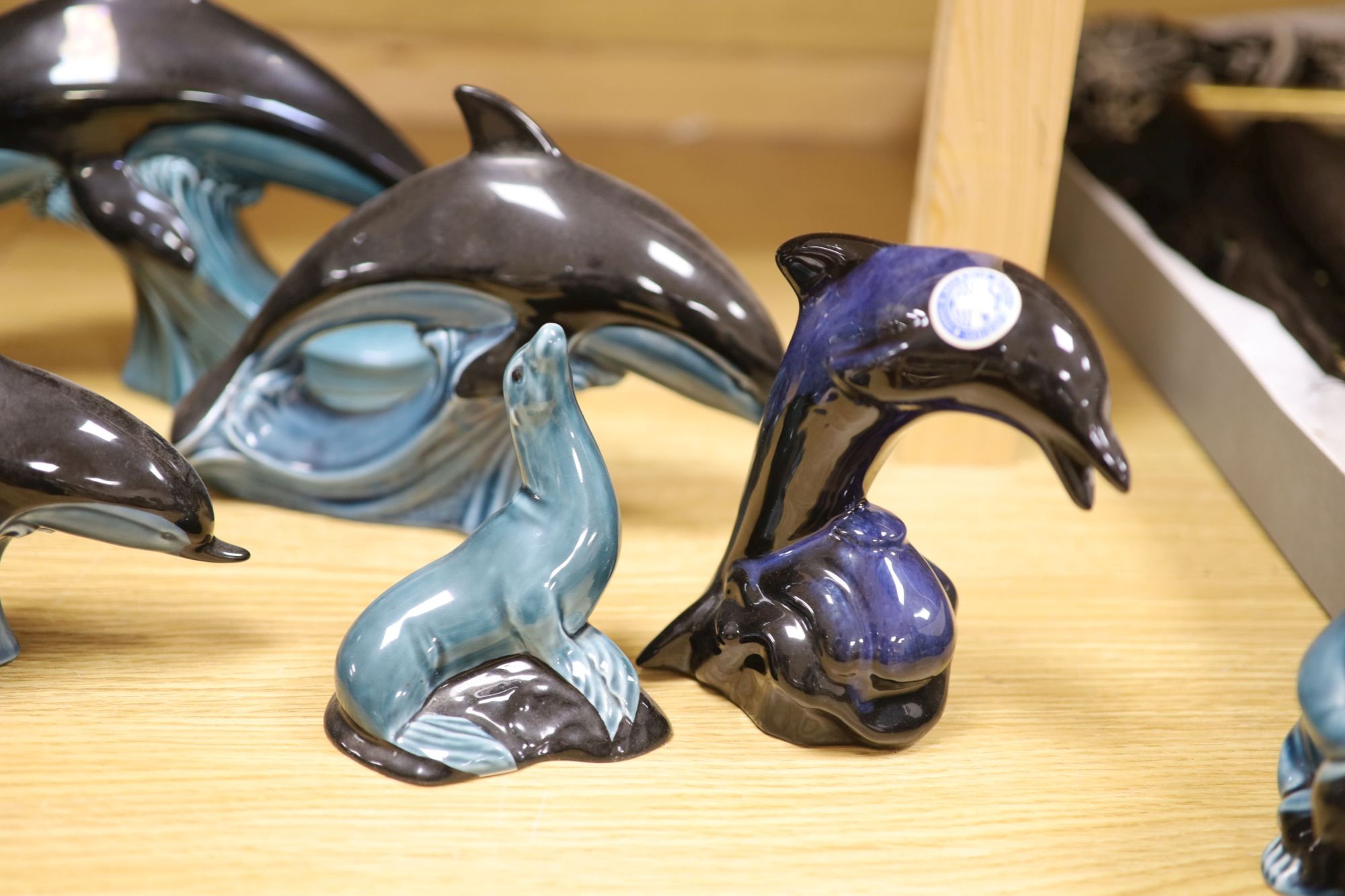 Six Poole pottery dolphins together with two similar seals and an otter